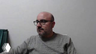 Кадр из записи трансляции: врач‑гастроэнтеролог Альмасри Али Мохамад перед камерой, сидит в свитере и в очках.