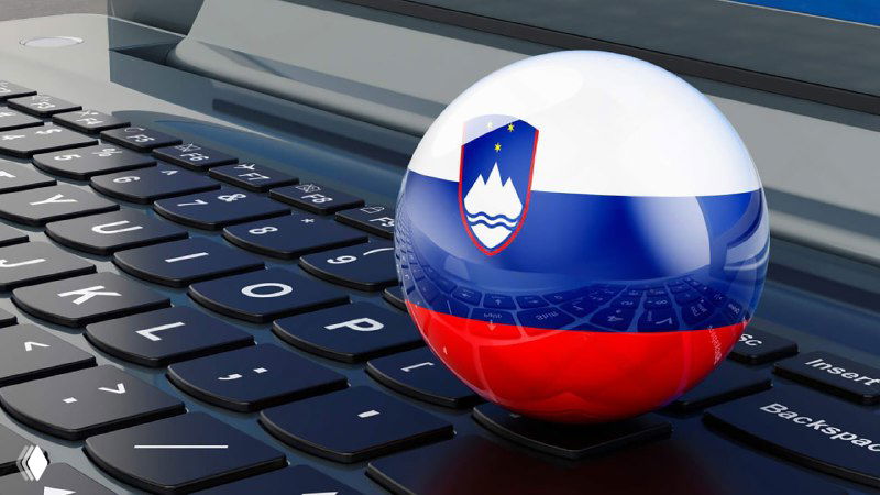 Шар с флагом Словении, установленный на клавиатуре ноутбука; иллюстрация к объявлению о запуске ВНЖ для digital‑nomads.