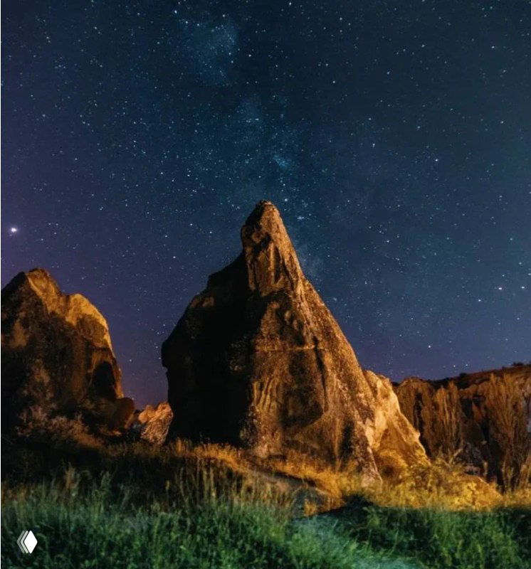 Высокие каменные скалы ночью под звёздным сводом: прочный, статичный ландшафт, помогающий почувствовать надёжность и внутреннюю опору.