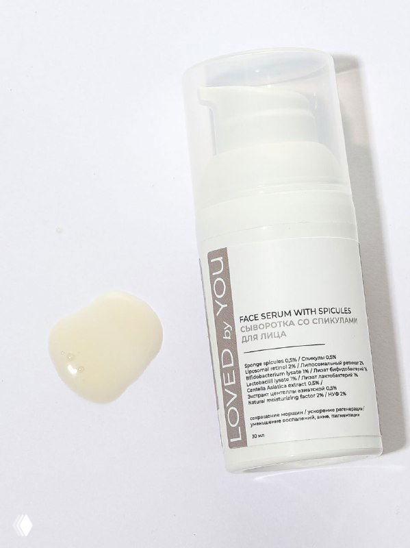 Флакон сыворотки Loved by You с пробиотиками и спикулами на светлом фоне; рядом капля текстуры продукта.