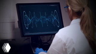 Лаборант в белом халате за компьютером анализирует данные и графики — иллюстрация научного подхода к разработке косметических формул.