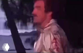 Размытый стоп-кадр видео: мужчина в светлой куртке идёт по улице ночью, кадр не демонстрирует косметику и выглядит как иллюстрация.