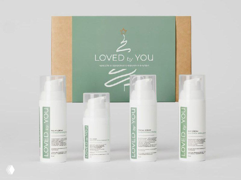 Фотография четырёх белых флаконов с дозаторами на нейтральном фоне и зелёной коробкой Loved by You — линия средств для укрепления барьерной функции кожи.