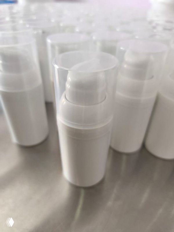 Непрозрачные белые флаконы с системой помпы на рабочем столе, иллюстрирующие упаковку, защищающую формулу от воздуха и окисления.