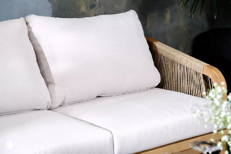 Крупный план мягкой белой подушки на плетёном диване коллекции TALARA — текстура ткани и удобная набивка для комфортного отдыха.