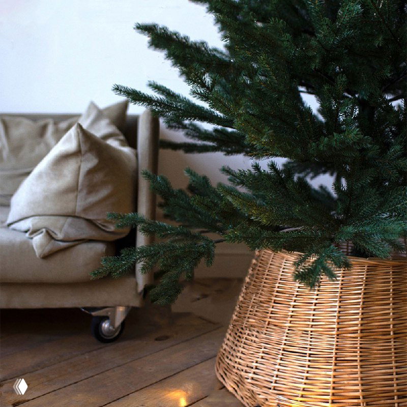 Нижняя часть ёлки и плетёная корзина-подставка: боковой ракурс литой модели «Уральская» 210 см рядом с мебелью в комнате.