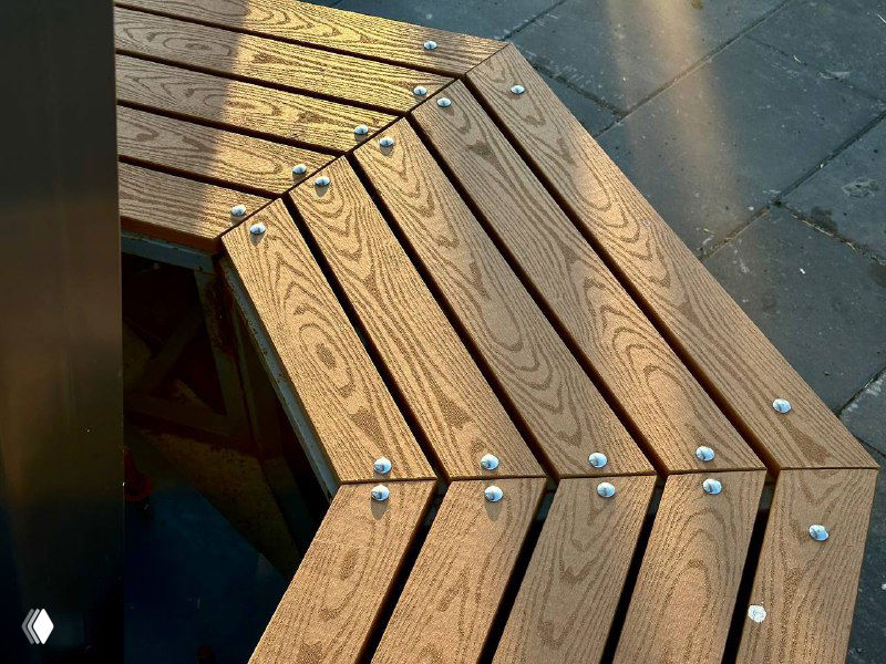 Крупный план террасной доски ДПК: заметна текстура ламелей, металлические крепежи и ровный цвет материала при естественном освещении.