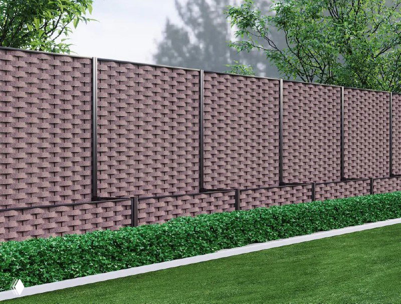 Длинный забор из панелей полимерной коры коричневого оттенка на фоне газона и кустарников; визуализация ограждения как альтернативы деревянному забору.