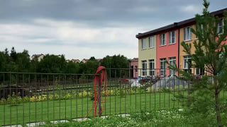Видеопревью участка и ограждения: металлическая решётка на переднем плане и дом с садом за ней, демонстрация альтернативного вида ограждений.