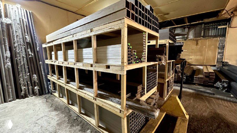 Стеллажи и упаковки с металлическими и ДПК элементами на складе — ракурс рабочего помещения и образцы товара на полках