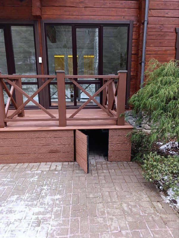 Терраса с красной (коричневой) террасной ДПК‑доской Polivan у деревянного дома — пример контрастного оформления пола и фасада.