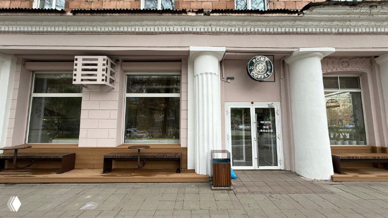 Широкий вид фасада кафе Port Coffee с двумя зонами отдыха на настиле Polivan: скамьи по обе стороны входа и урна на тротуаре.