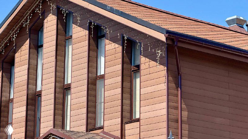 Фасад дома, облицованный панелями из древесно‑полимерного композита: ровные швы, однородный цвет, стойкость к солнцу и погоде на фото