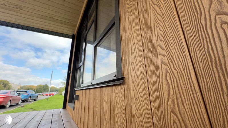 Крупный план текстуры фасадной доски Polivan SINGARAJA: имитация древесных волокон, тёплый песочный оттенок, стык у окна и внешняя отделка.