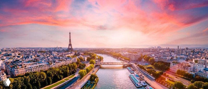 Панорамный вид Парижа с Эйфелевой башней и рекой Сеной при розово-оранжевом закате — атмосферное фото о жизни и переезде во Францию.