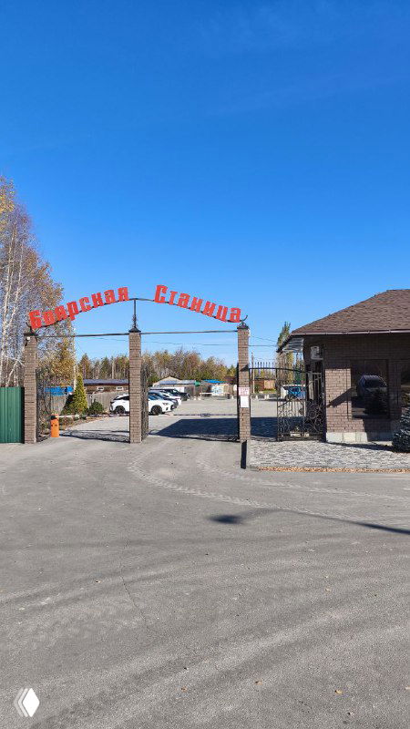 Въездная арка с надписью «Боярская Станица» у входа на территорию отдыха, асфальтовая дорога и парковка в ясную погоду.