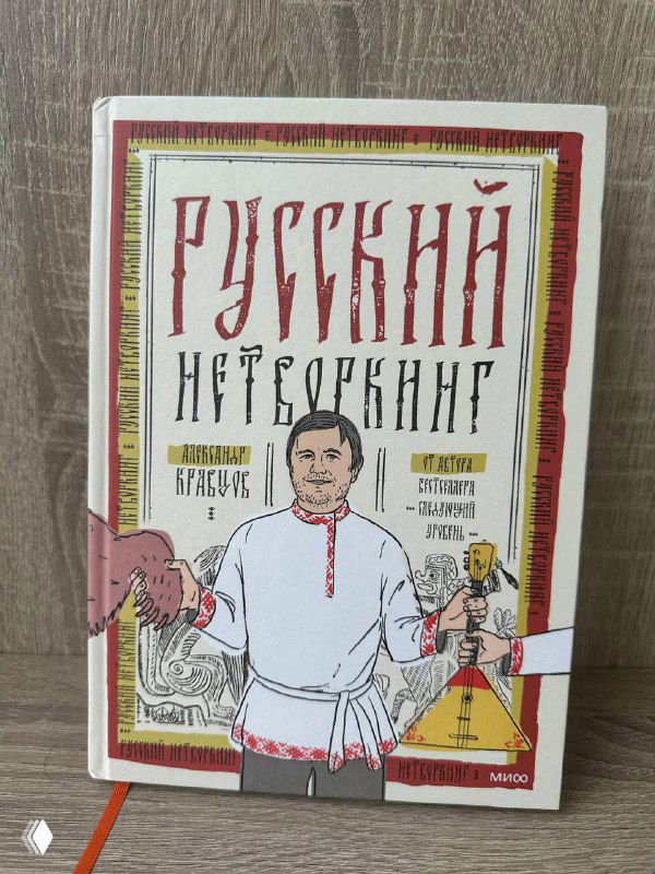 Обложка книги «Русский нетворкинг»: рисунок мужчины в рубашке, декоративный шрифт названия и элементы в русском стиле, книга лежит на столе.