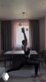 Женщина в спортивной форме делает выпад в жилой комнате — кадр шутливого видео про отношение автора к экономике.