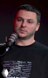 Кадр превью: мужчина в студии подкаста у микрофона в тёмной футболке, студийное освещение и крупный план лица в превью эпизода