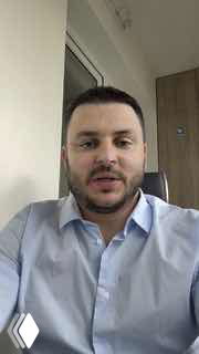 Портретное селфи автора канала Тараса Алтунина в голубой рубашке в интерьере офиса — фото для анонса выступления на деловом форуме в Москве.