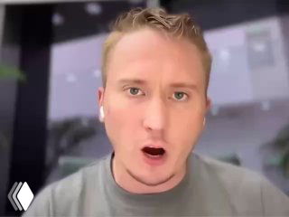 Кадр с записанного эфира: выступление молодого мужчины в наушниках, эмоциональная мимика, размытый фон экрана