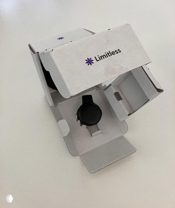 Распакованный комплект Limitless Pendant в коробке: виден сам круглый пэдж и внутренняя упаковка, снято крупным планом на столе.