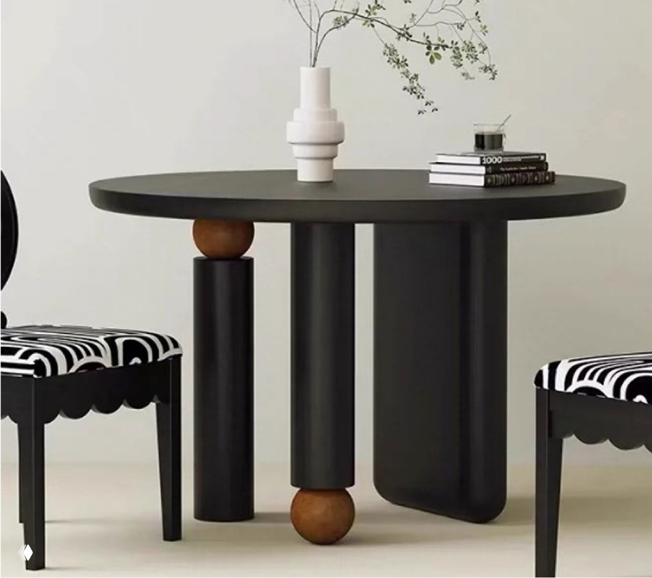 Крупный план стола из ясеня: тёмная круглая столешница, массивные цилиндрические ножки и декоративные деревянные шарики.