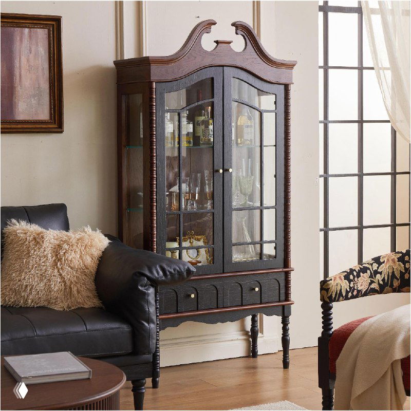 Шкаф из массива дуба в интерьере гостиной: высокий корпус с витражными стеклянными дверцами, резной карниз и тёмная отделка.