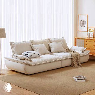 Светлый бежевый диван Галеон с объемными подушками в уютной комнате с ковром и деревянной тумбой, показан общий интерьерный контекст.