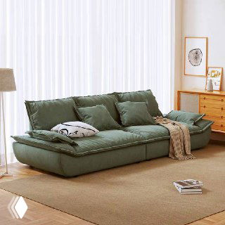 Зеленовато-серый диван Галеон с подушками и легким пледом, показан в уютном интерьере с естественным освещением и мягким ковром.