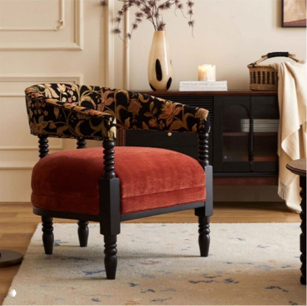 Фотография кресла из массива дуба в интерьере: красная бархатная сидушка, узорчатая тканевая спинка и резные чёрные ножки.