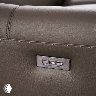 Детальное фото панели управления электромотора дивана Cowhide: кнопки реклайнера из металла на боковой части подлокотника.