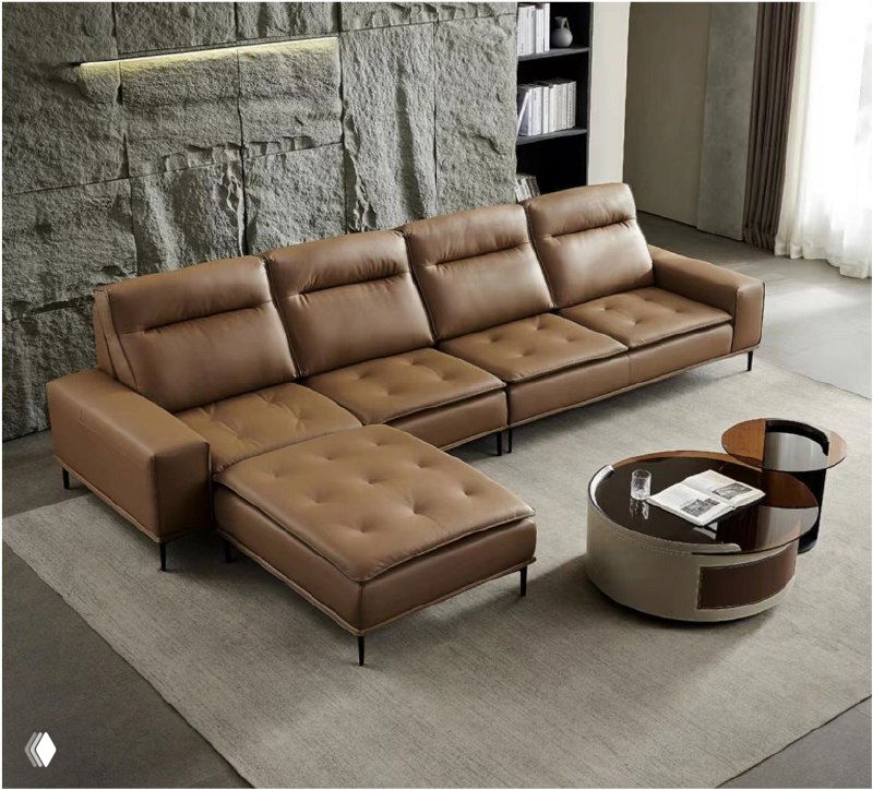Коричневый кожаный диван в интерьере на сером ковре: три посадочных места, оттоманка и журнальный столик рядом.