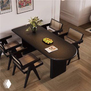 Темный овальный обеденный стол из массива дуба в интерьере: стол с сервировкой и четырьмя плетёными стульями в натуральных тонах.