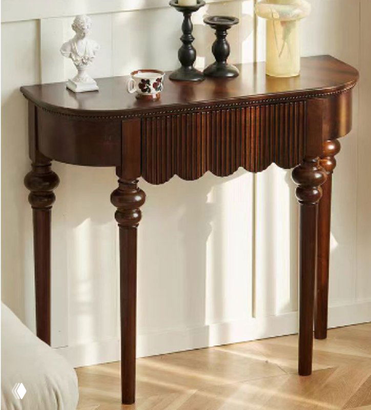 Фотография консоли из массива дуба тёмного оттенка в интерьере: полукруглая столешница, резные ножки и декоративные предметы сверху.