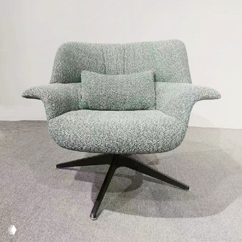 Кресло с мягкой текстильной обивкой светло-серого цвета на металлическом крестовидном основании, показано на нейтральном фоне.