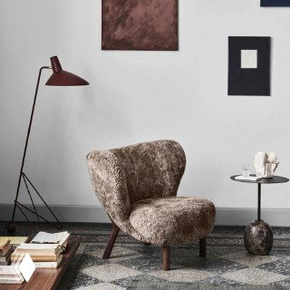 Плюшевое бархатное кресло на ясеневых ножках в светлой минималистичной комнате с торшером, низким столиком и стопкой книг