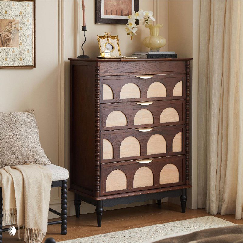 Комод из массива дуба в гостиной: тёмно-коричневый высокий комод с арочными светлыми вставками, рядом кресло и шторы, интерьерная сцена