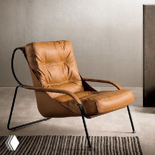 Фотография коричневого кожаного кресла с мягким PU-наполнителем, седельной кожей и тонкой черной металлической рамой в интерьерной постановке.