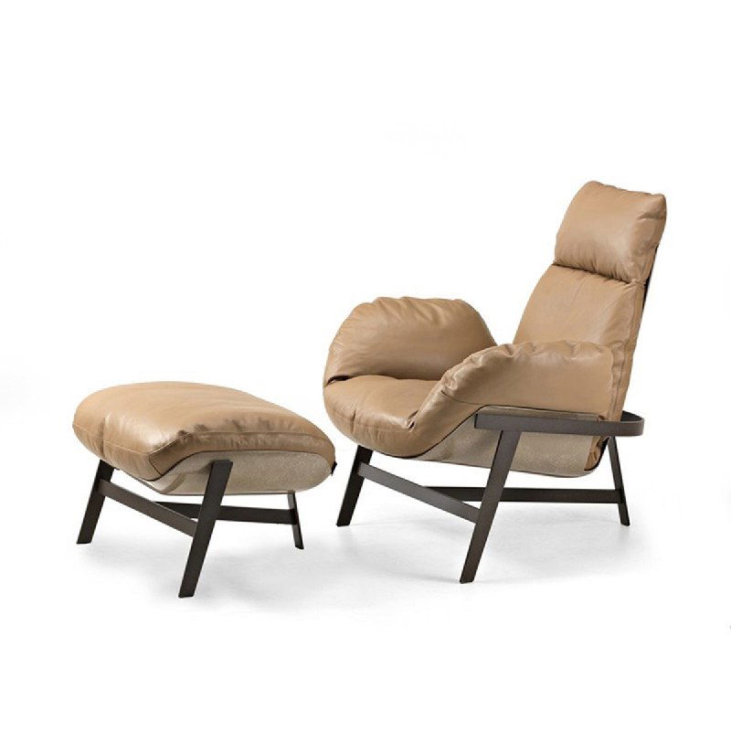 Бежевое кресло с оттоманкой на белом фоне: искусственная кожа, мягкая форма сиденья и видимый металлическо‑деревянный каркас, товар для интерьера.