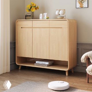 Светлый деревянный комод для обуви из массива дуба в спокойном интерьере: закруглённые углы, три дверцы и открытая нижняя полка для хранения