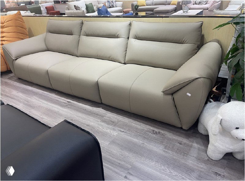 Бежевая трёхместная модель дивана в шоуруме на фоне других образцов мебели и напольного покрытия, вид спереди, размер 318×100×90.