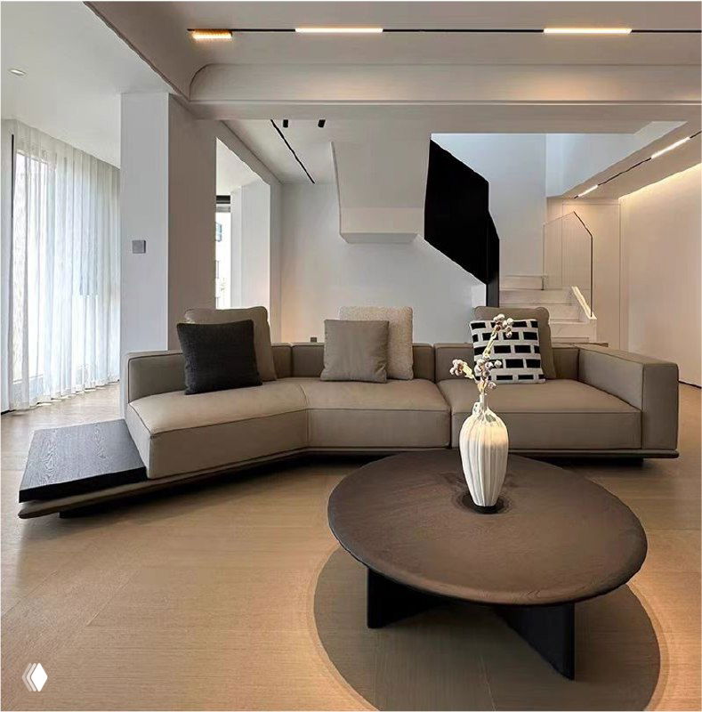 Светлый интерьер с современным угловым диваном, журнальным столиком и вазой; демонстрация формы, обивки и масштаба мебели в комнате.