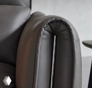 Крупный план изогнутой части подлокотника дивана Cowhide, акцент на мягкой набивке и кожаном покрытии.