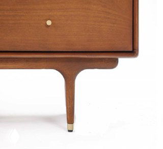 Низ и ножка комода из ясеня: элегантная тонкая опора с декоративными металлическими насадками и скульптурным профилем ножки.