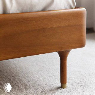 Деталь ножки кровати Madrid: тонкая шлифованная ножка из массива ясеня с металлической накладкой на конце и гладкой обработкой.