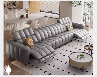 Серый угловой диван с двумя электромоторными реклайнерами и волнообразной прострочкой, размещён в светлой гостиной у журнального столика