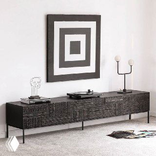 Тёмная ТВ тумба из ясеня с резным геометрическим узором на фасадах, размещённая в светлом современном интерьере, вид спереди и справа.