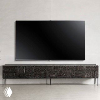 Телевизор над низкой тумбой из ясеня: тумба тёмного тона со скульптурным резным рисунком и минималистичным окружением.