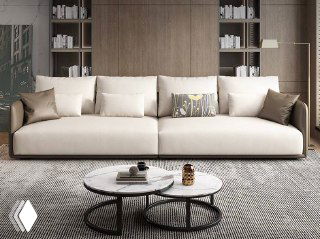 Бежевый модульный диван в современном интерьере, вид спереди с декоративными подушками и кофейным столиком на светлом ковре.